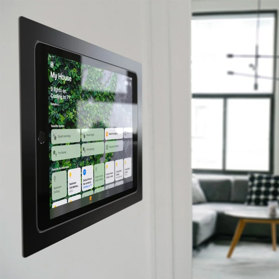 Smart home control panel mounted on a white wall, showing various home automation options.