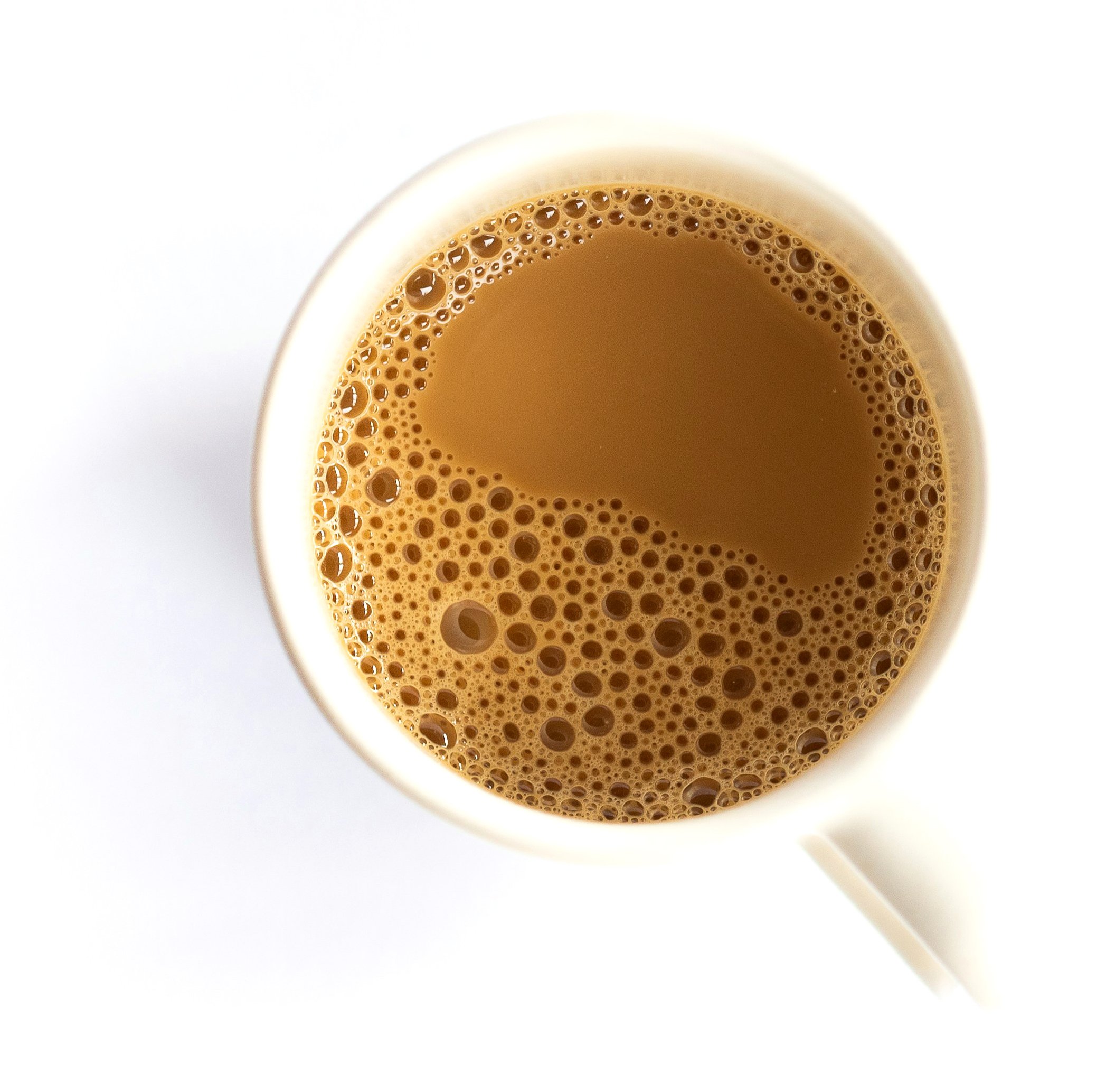 A top-down view of a white mug filled with tea,