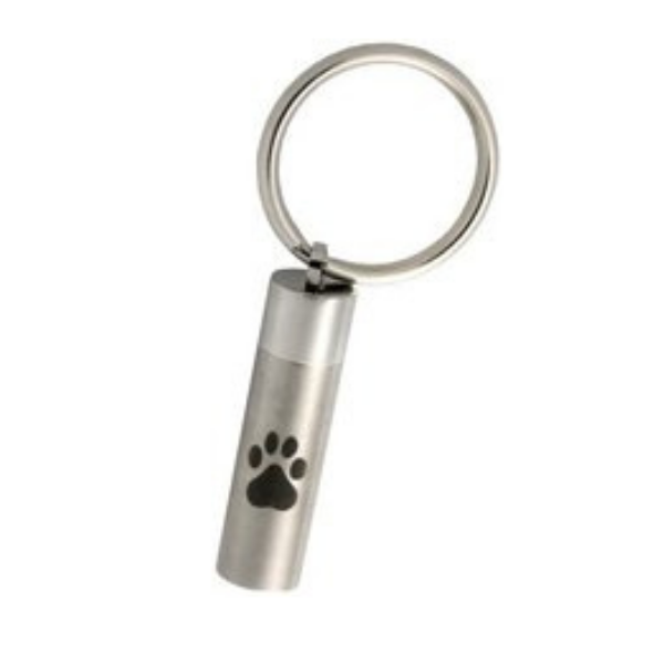A silver pet ID tag with a black paw print design, attached to a keyring.