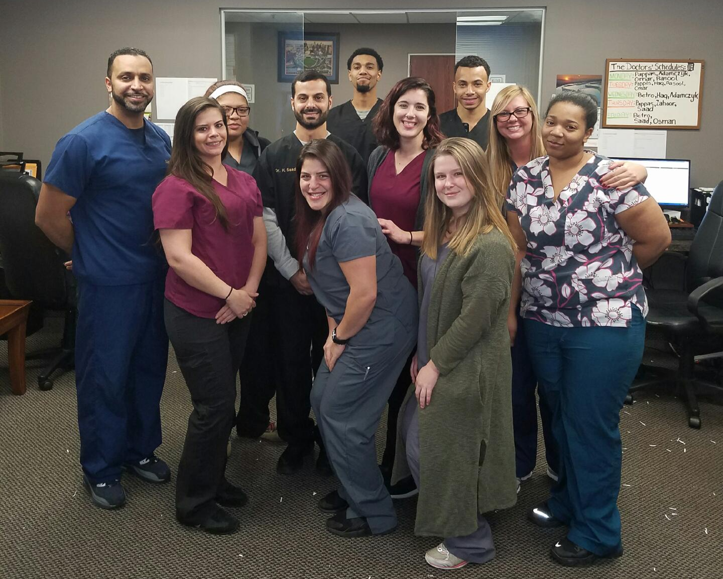 "Inside the Fisher Building Medical Center: The Management Service Team (MSO) at the end of a high-velocity day. Look closely at the whiteboard in the background—that was our reality. Three to four physicians per day, maintaining a relentless pace of