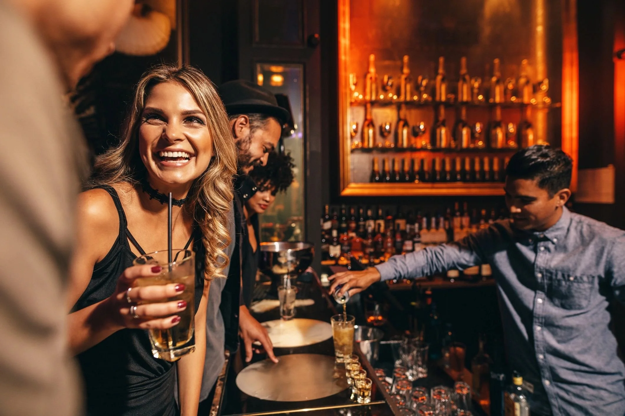 People in a dimly lit bar enjoying drinks and socializing.
