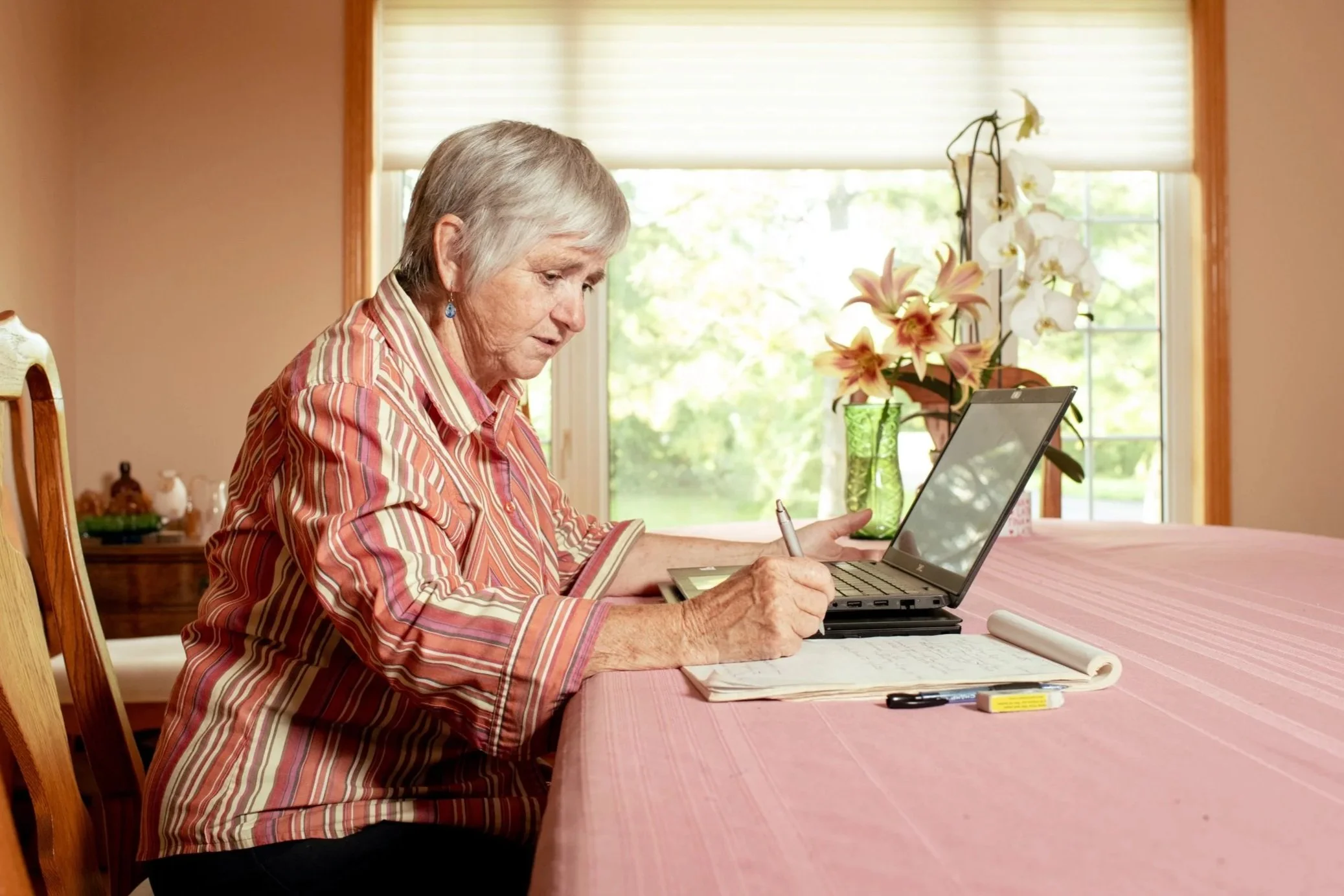 Theresa Bergeron working from home on her laptop, taking notes.