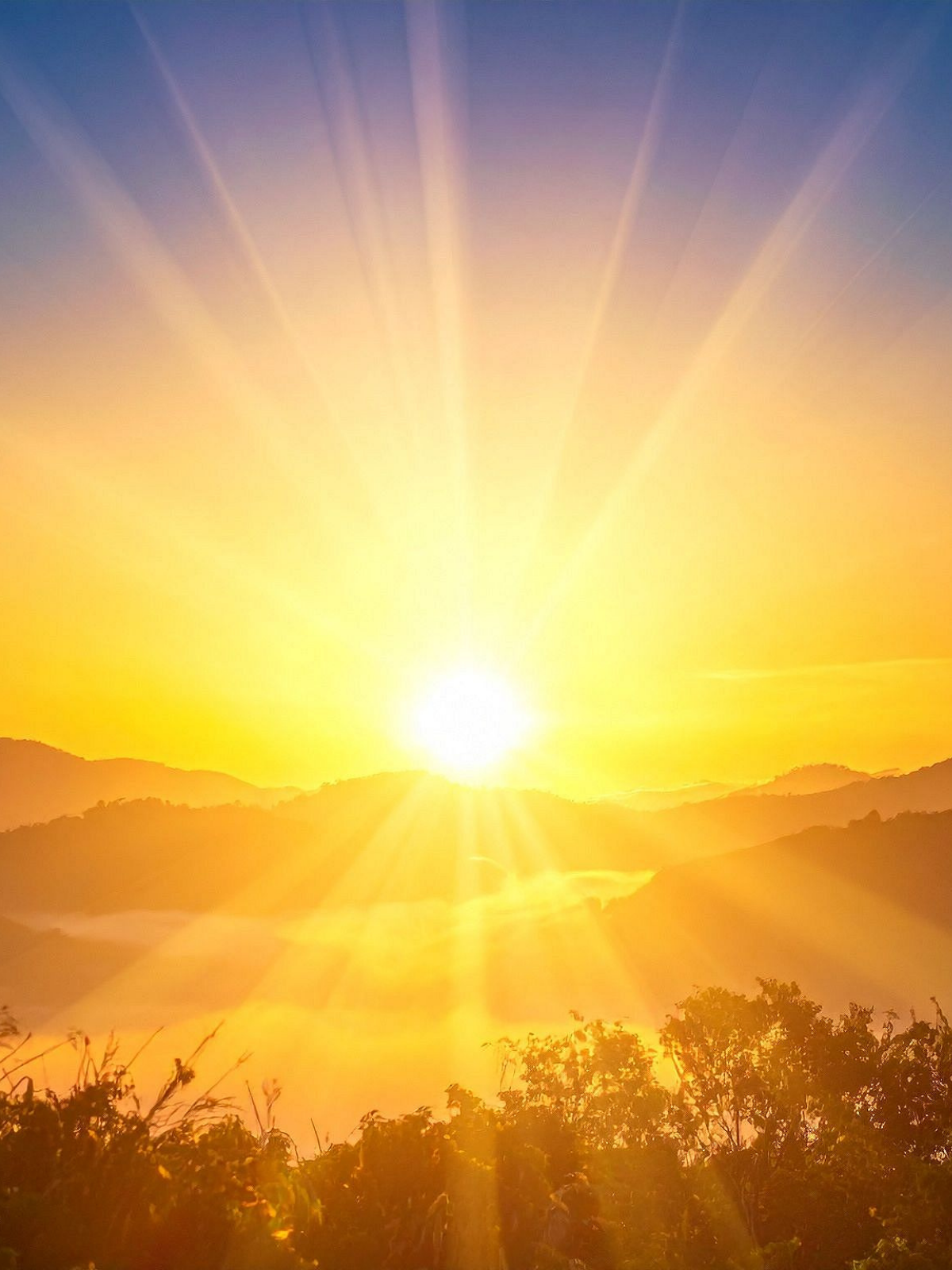 Sunrise over mountains with bright sun rays and a clear sky