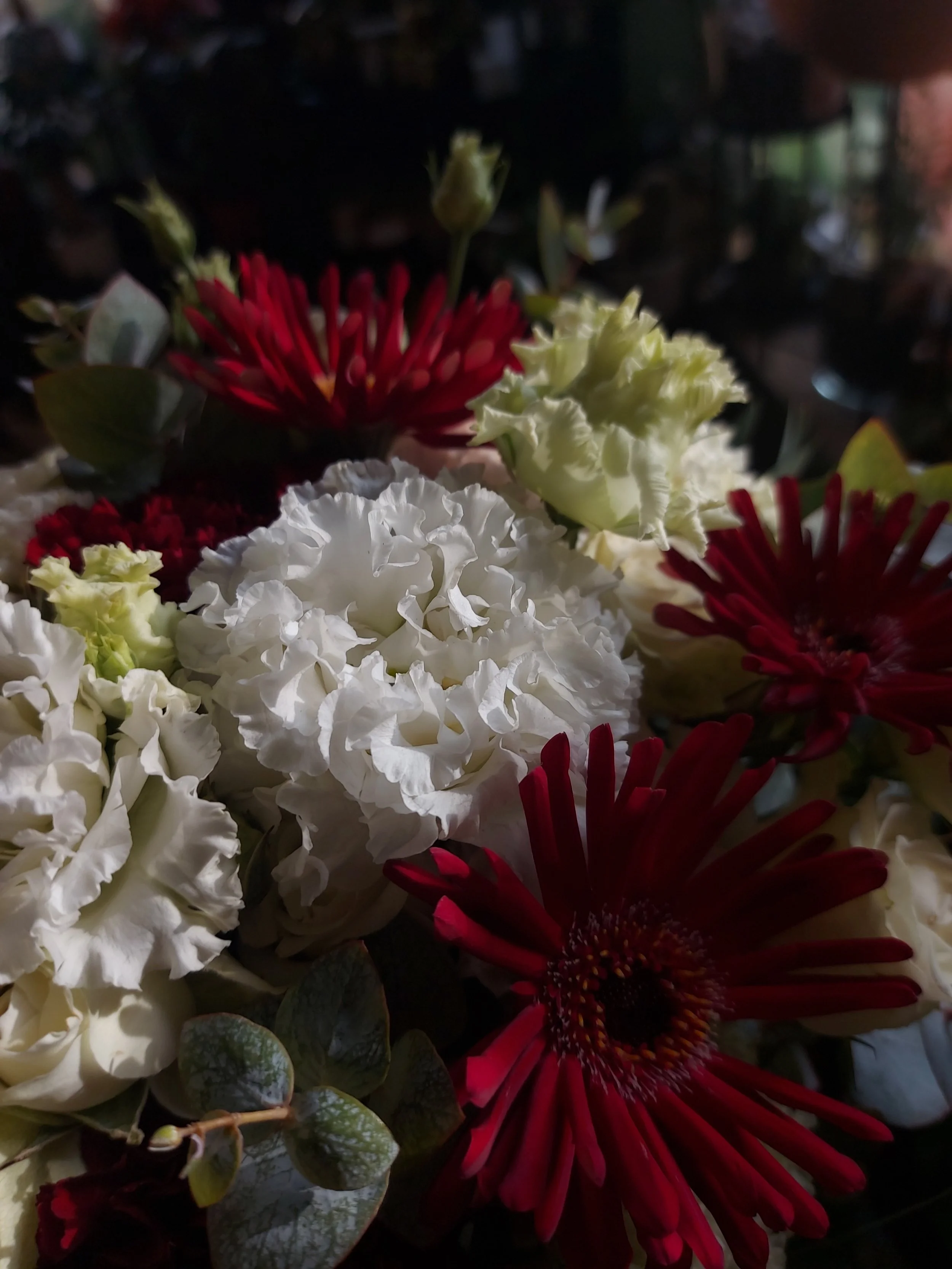 A close-up of a wedding bouquet made with white and red flowers.