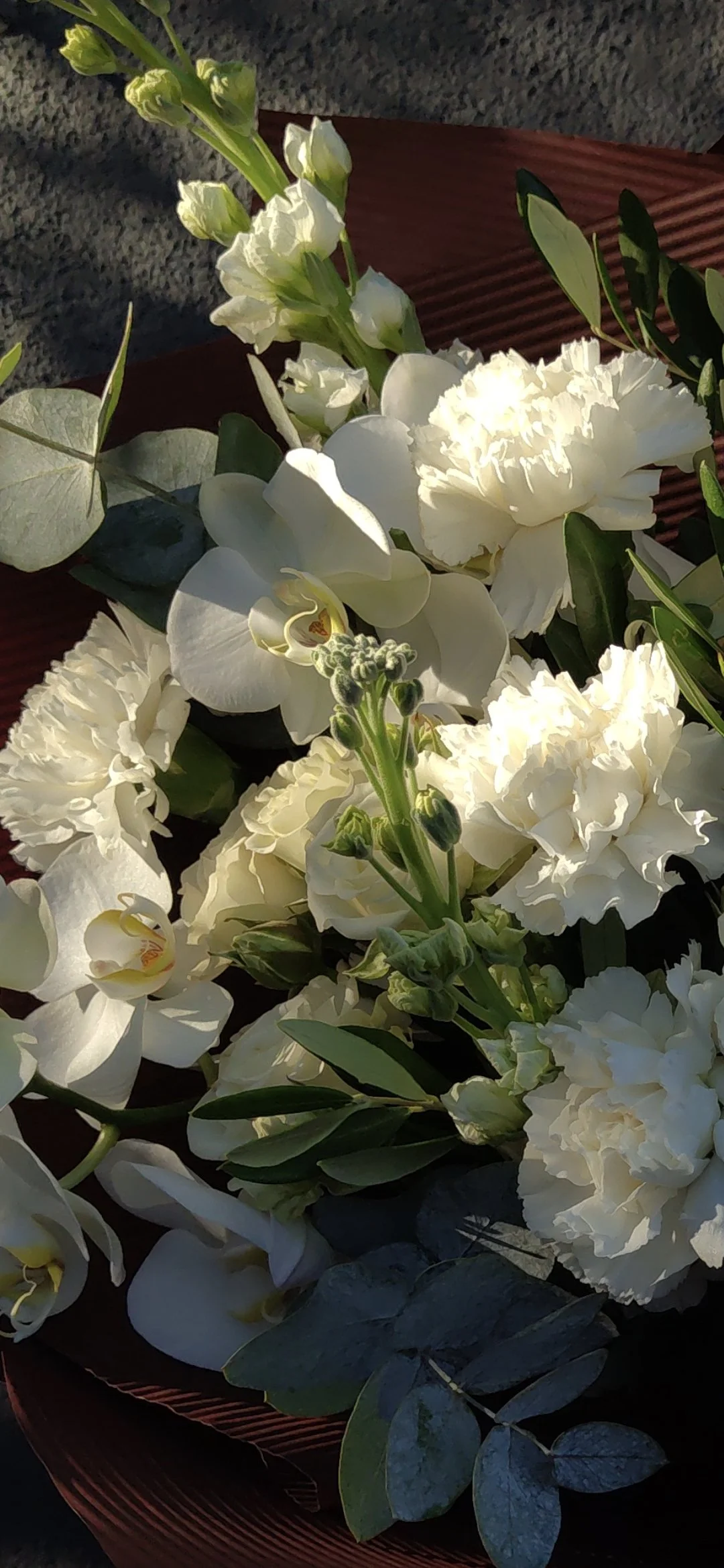 White flowers, including orchids, carnations, and matthiolas, in a modern arrangement.