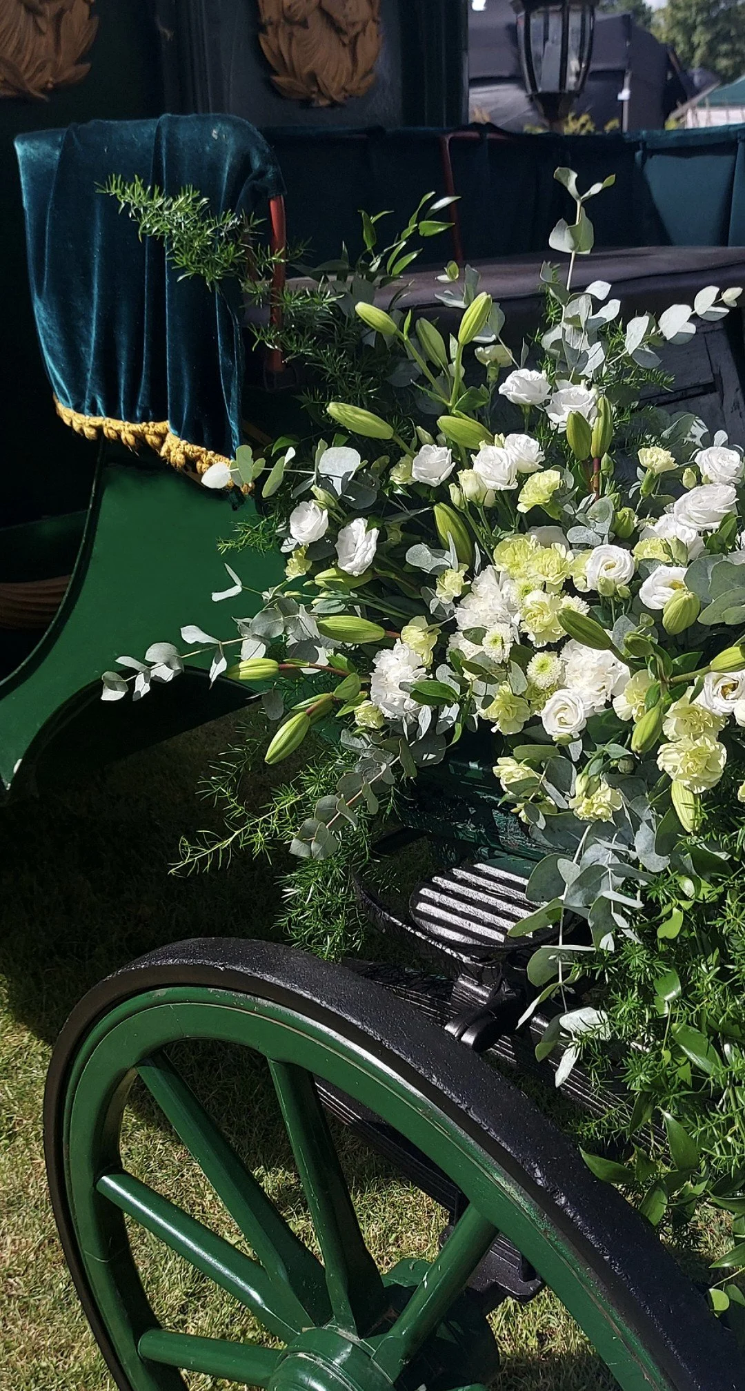 A wedding carriage decorated with assorted white flowers.
