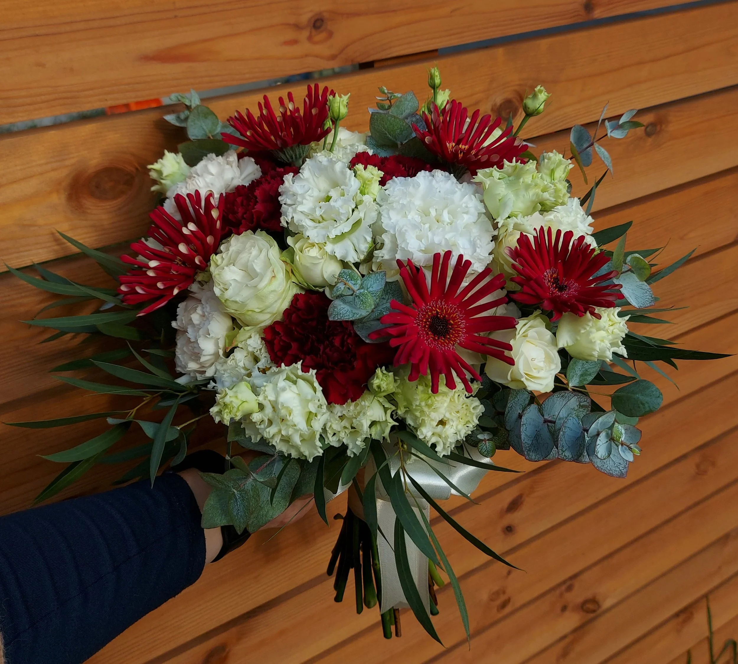 A bridal bouquet with a bold  color combination and a boutonniere.