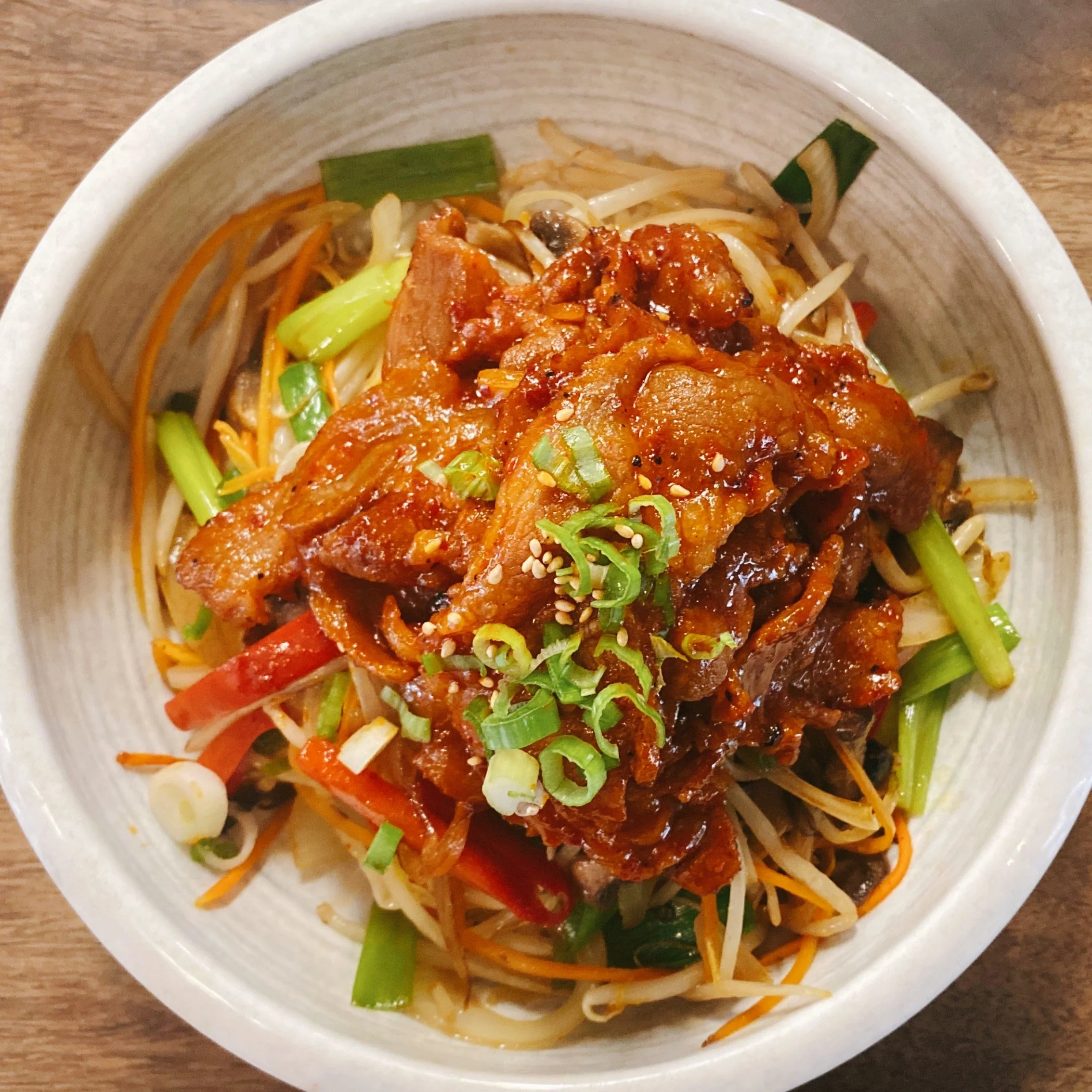 Bowl of noodles with vegetables and some spicy sauce