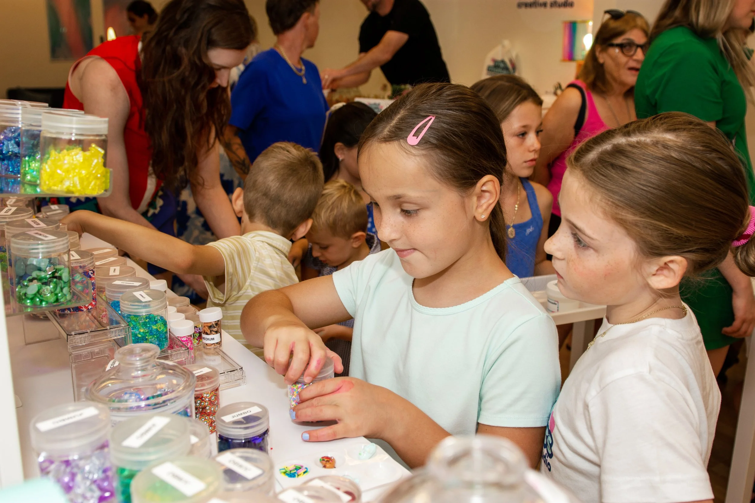 Kids choosing charms and sprinkles to customize their slime