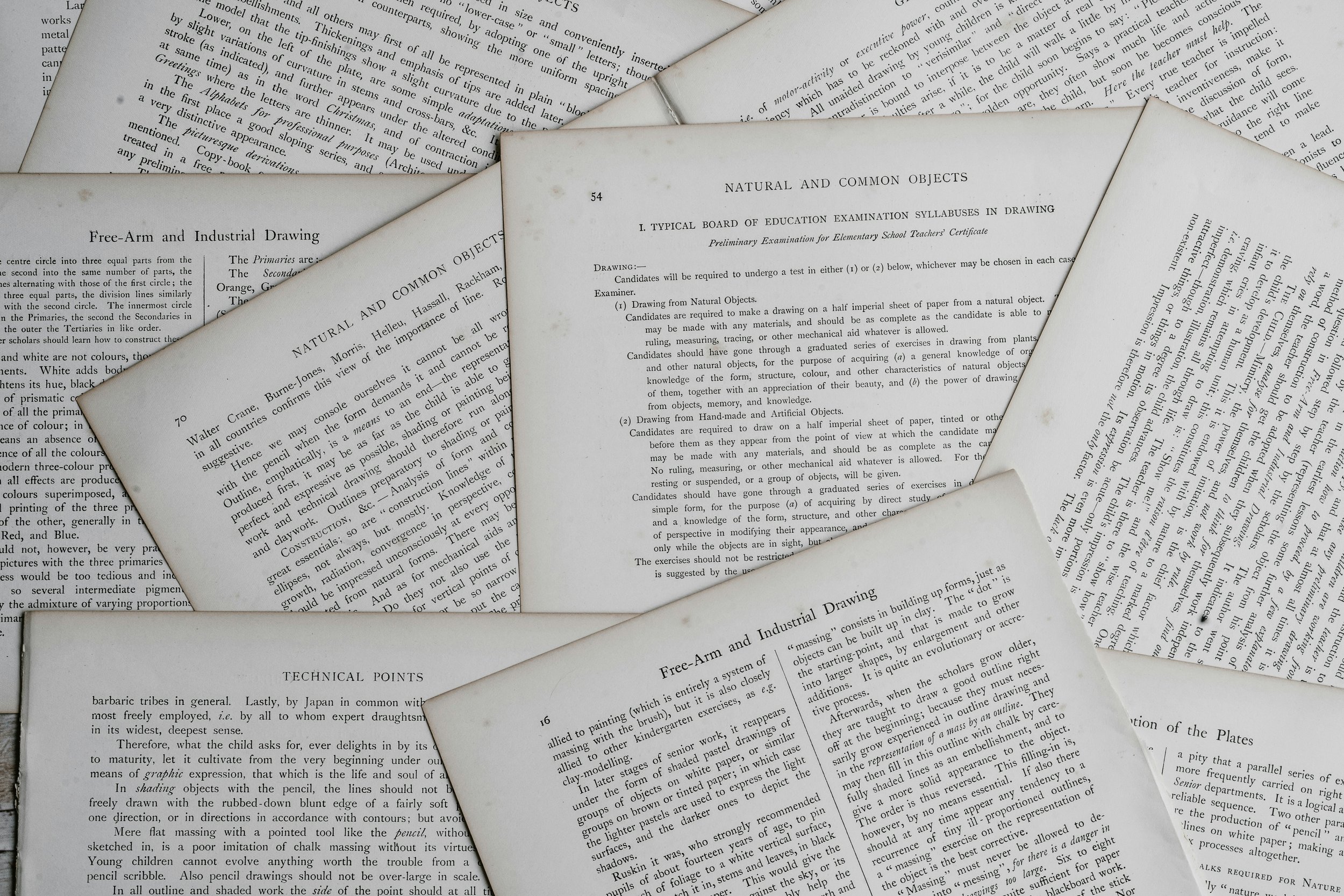 A close-up image of several overlapping pages of printed text, including sections titled "Natural and Common Objects" and "Free-Arm and Industrial Drawing."
