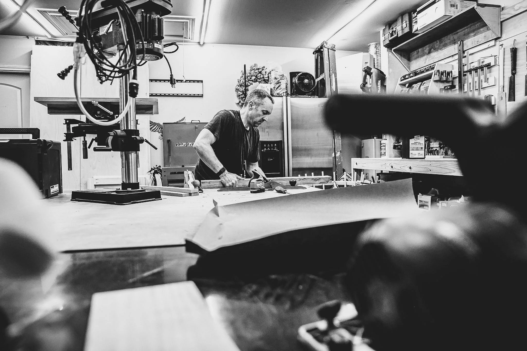 A man working in a workshop with various tools and equipment around him.