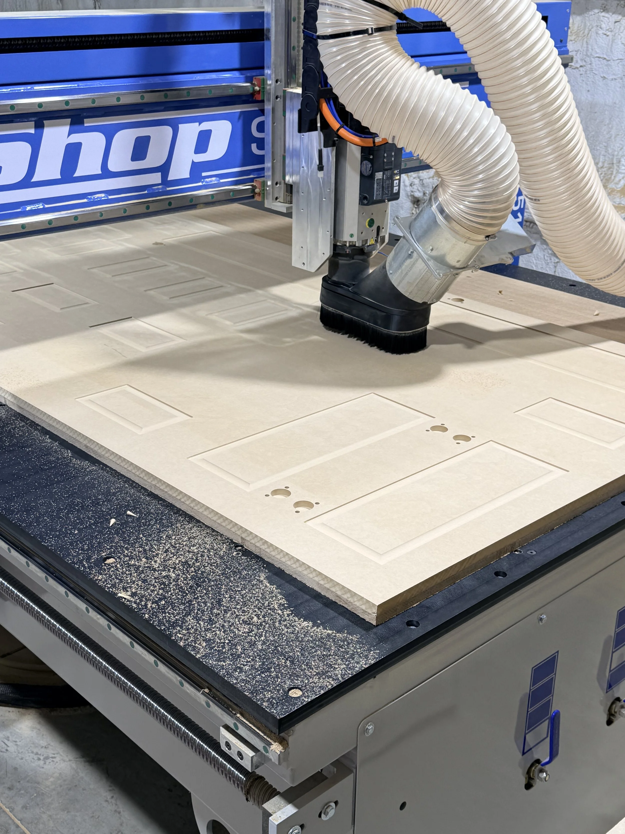 CNC machine precision cutting HDF cabinet doors at a local kitchen refacing manufacturer in Delaware, OH during custom cabinetry production.