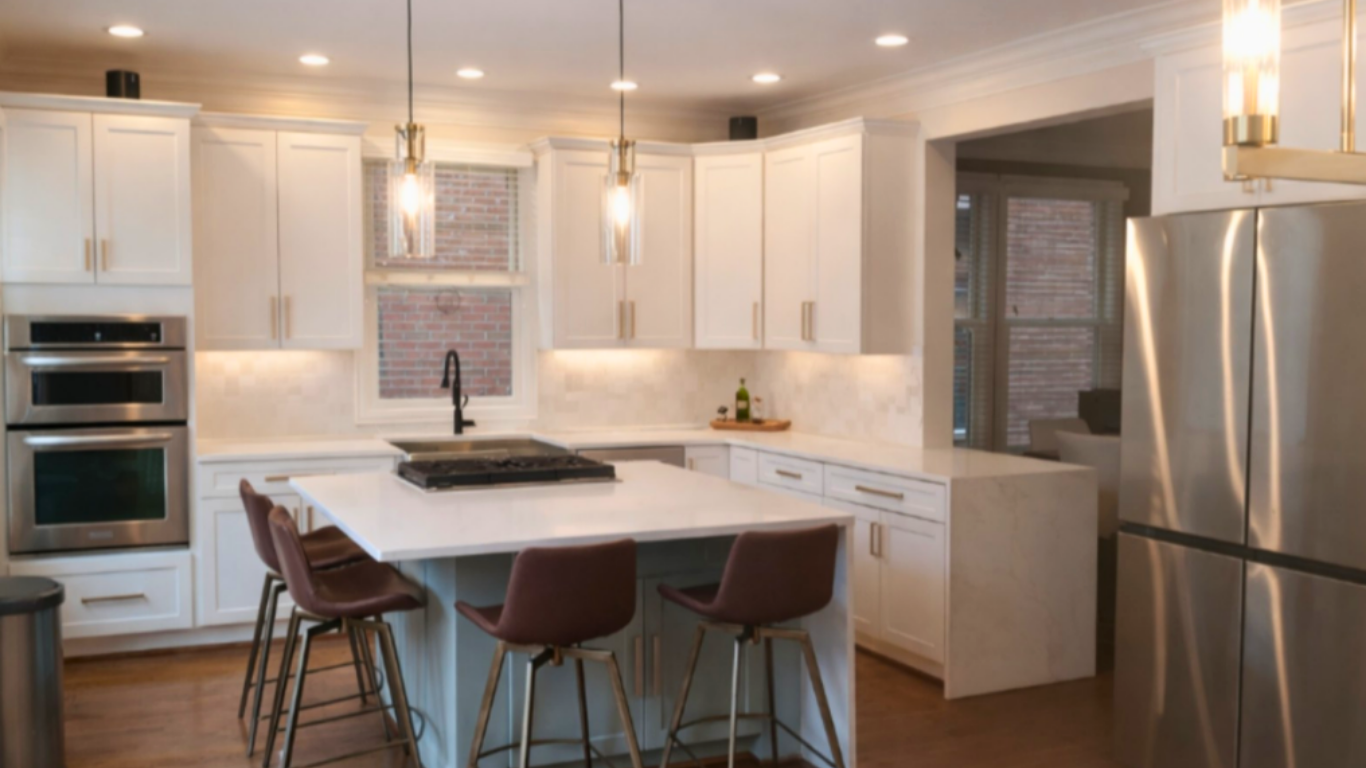 Warmly lit kitchen featuring white cabinets, a central island with leather barstools, and cylinder pendant lights.
