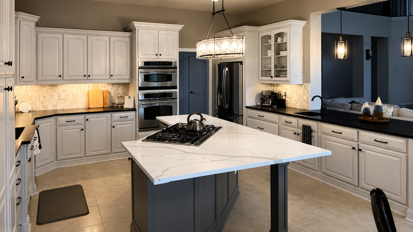 Modern kitchen with white cabinets, black countertops, a marble island with a stove, stainless steel appliances, and pendant lighting.