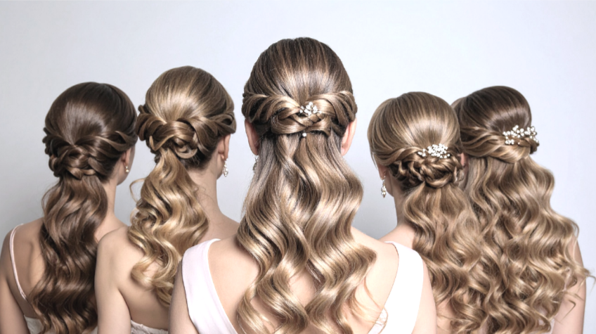 Five women with styled, wavy blonde hair sitting with their backs facing the camera, each with unique braided hair accessories.
