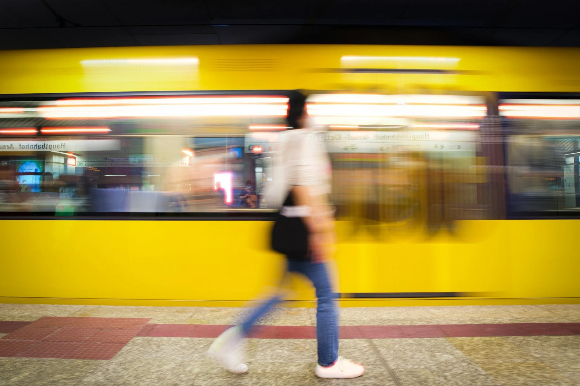 a blurred motion photo of a person walking in front of a train