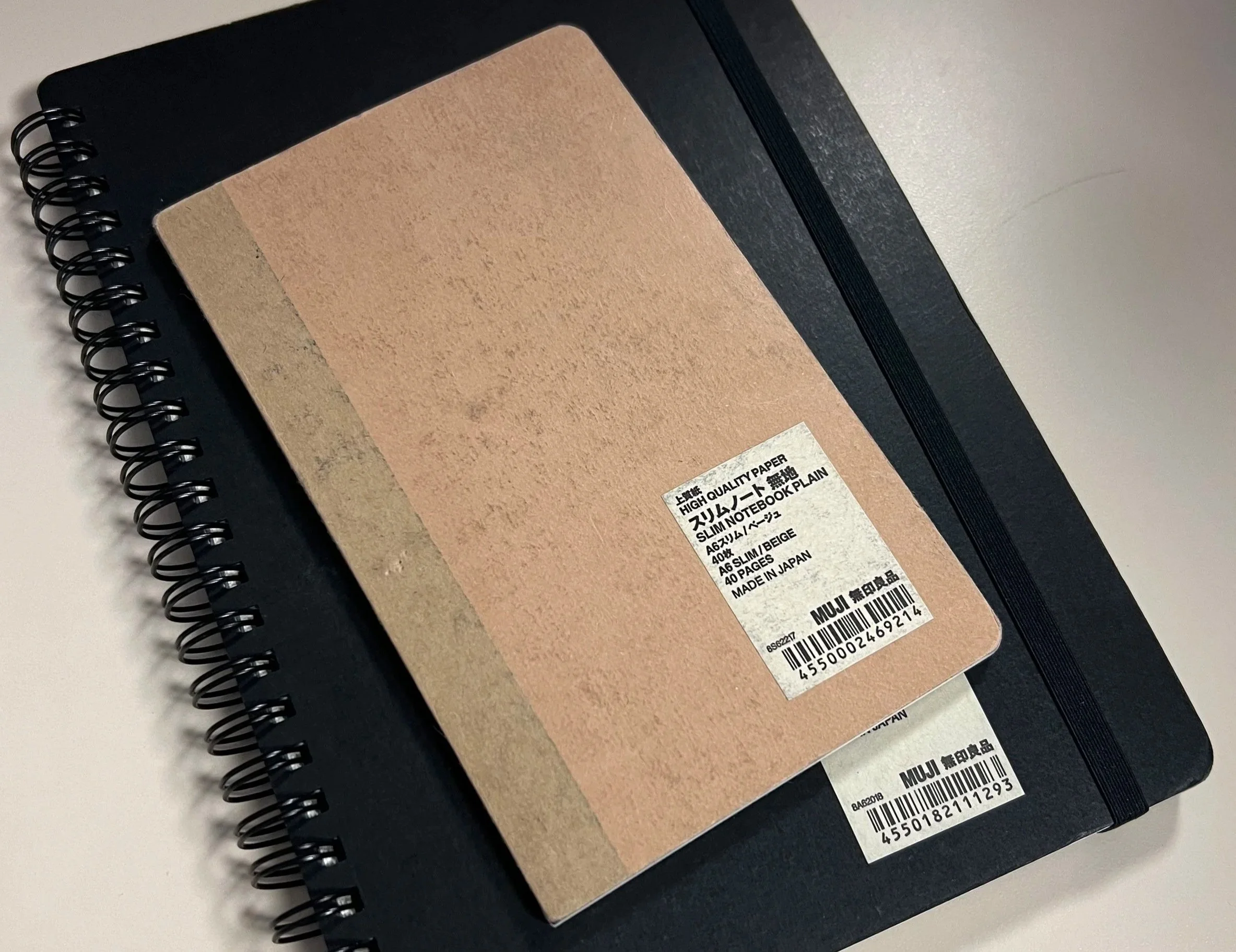 Image of brown notebook stacked on top of a black notebook