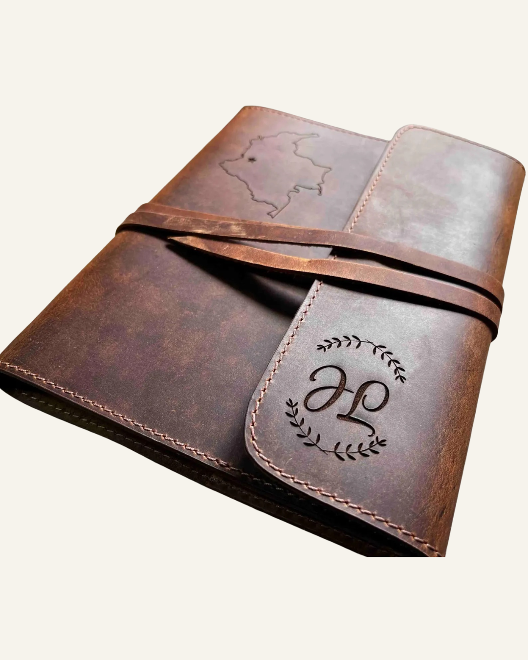 brown leather journal, with initials JL on the tab and an outline of country on the front