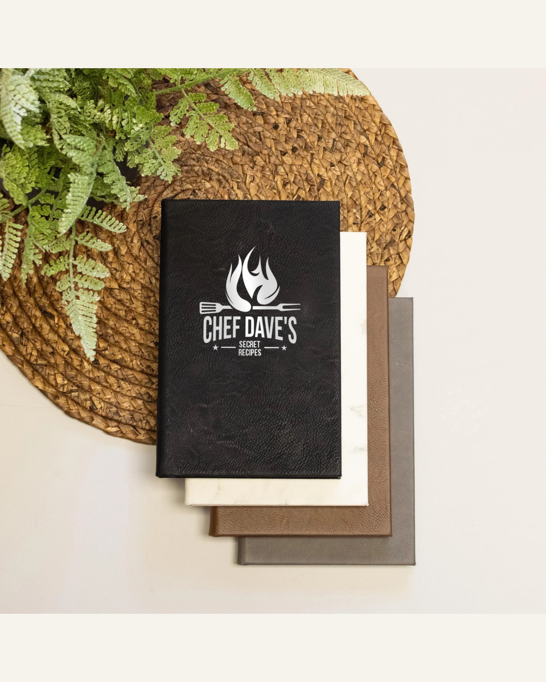 black personalized recipe book, brown place mat, green plant