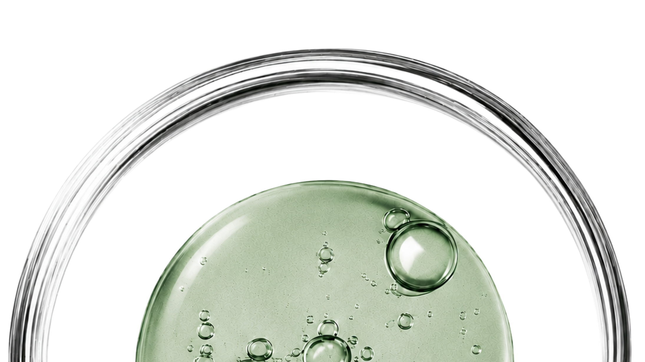 Close-up of a glass with green liquid and bubbles inside, viewed from the top.