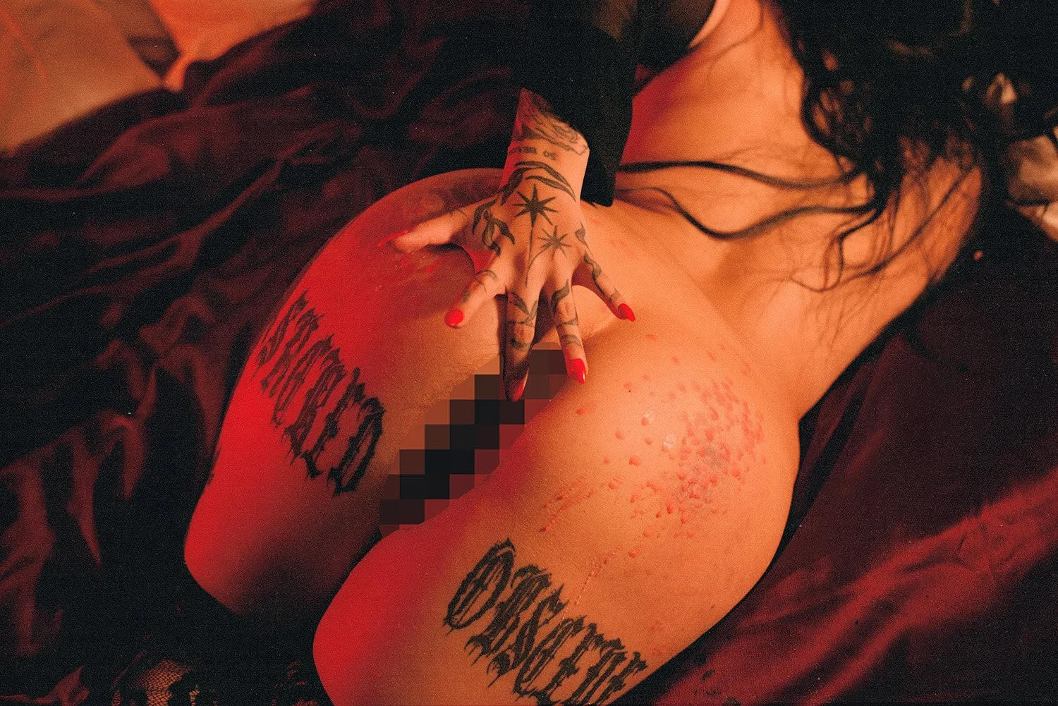 A woman tucking a butt plug in with her hand, censored, posing for an erotic photography session in Toronto, ON