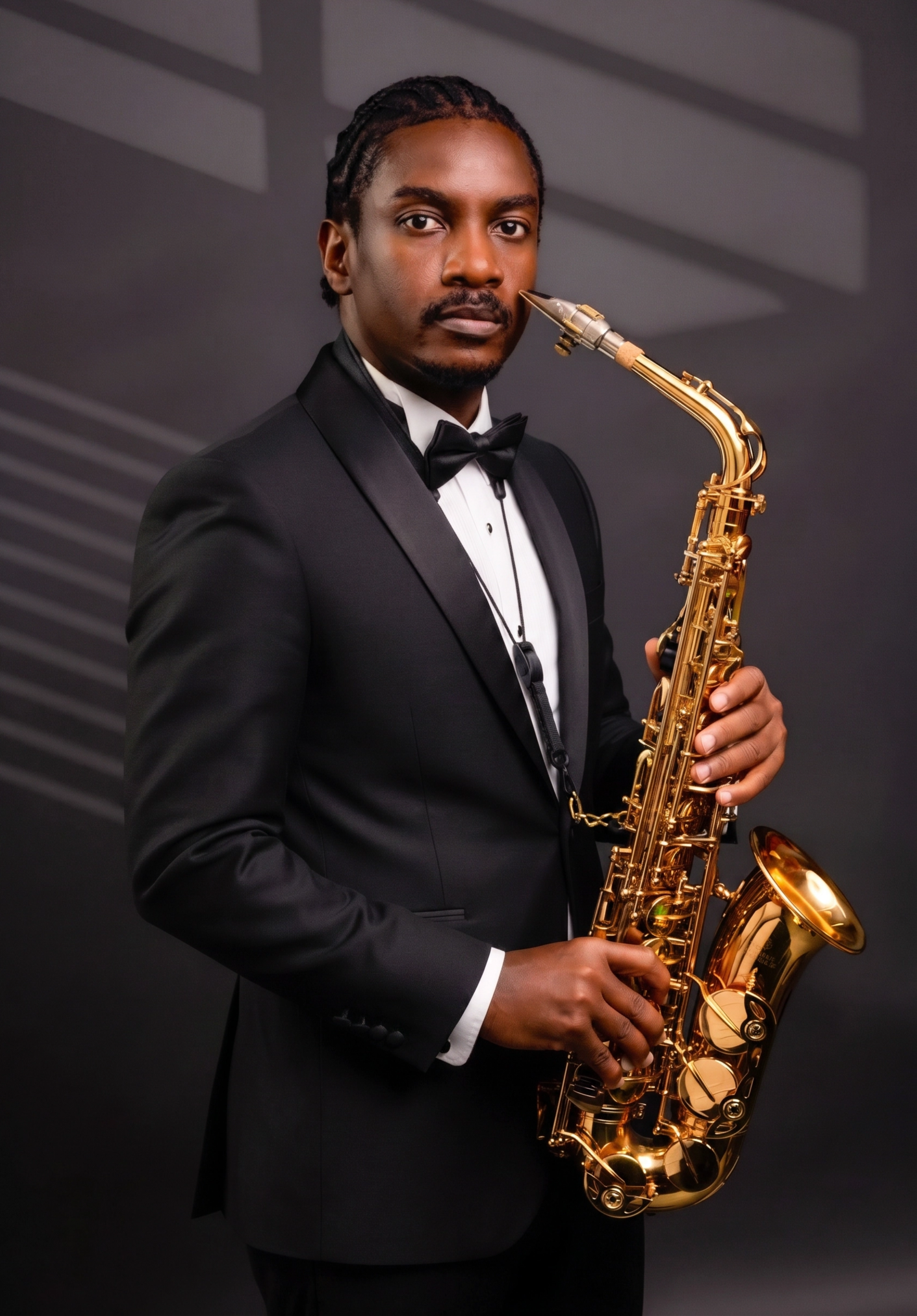 A man in a black tuxedo and bow tie playing a gold saxophone.