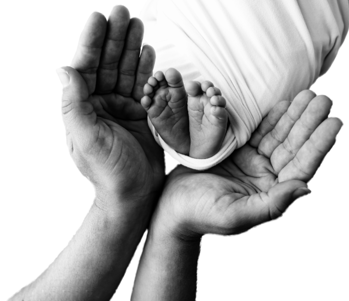 Two adult hands gently holding a baby's feet, symbolizing care and protection, in black and white.