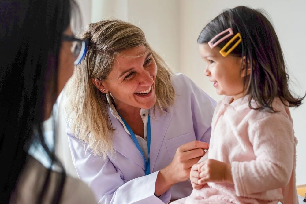 Pediatric healthcare professional caring for a young child, representing compassionate care and earlier diagnosis through genetic testing.