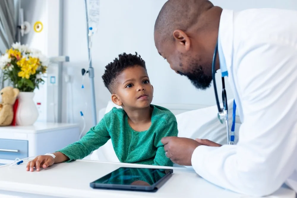 Pediatric healthcare professional talking with a young patient during a hospital visit, representing personalized care and informed genetic testing decisions.