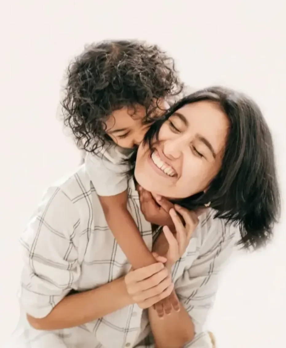 Parent and child sharing a joyful embrace, representing family support and the positive impact of earlier genetic diagnosis.