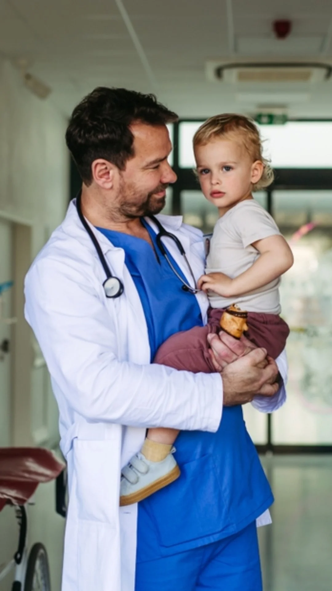 Pediatric healthcare professional holding a young child, representing compassionate care and the importance of genetic testing for earlier diagnosis.