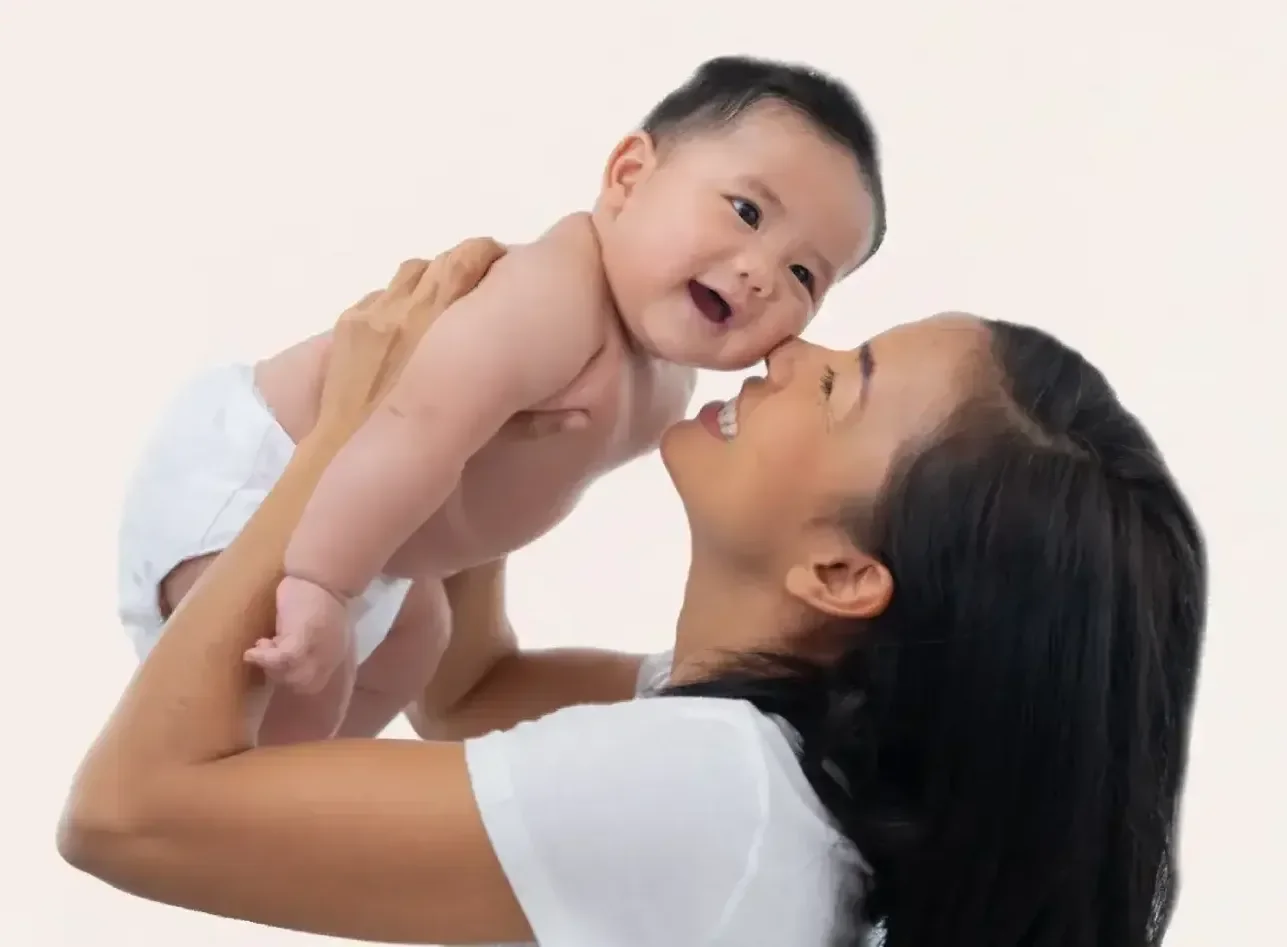 Parent holding a smiling baby, representing the importance of early childhood care and genetic testing for timely diagnosis.