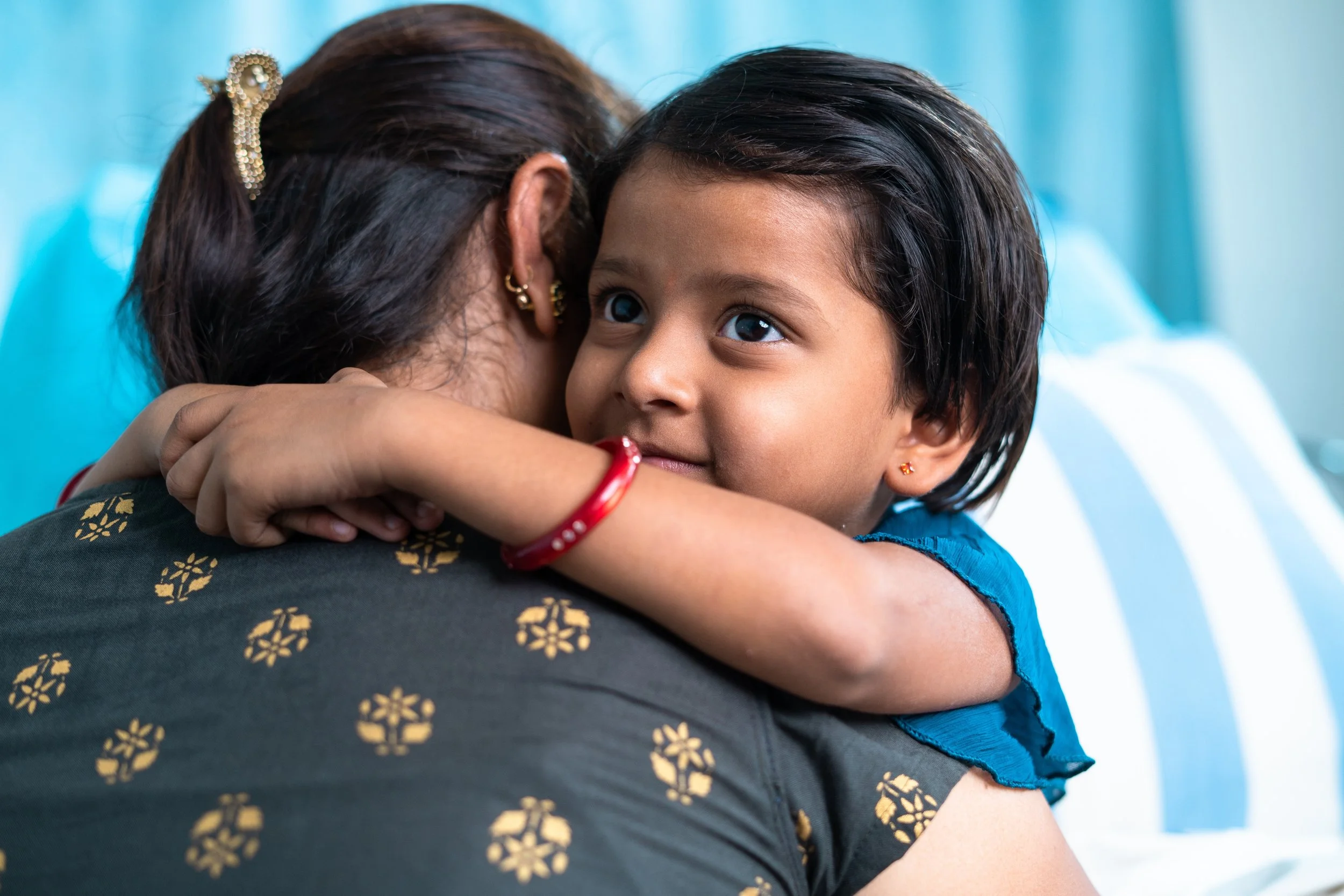Parent embracing a young child, representing family support throughout the genetic testing and diagnostic journey.