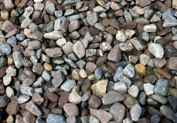 A large area covered with small, smooth pebbles of various shades of gray, white, beige, and tan.