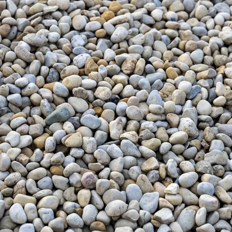 A large area covered with small, smooth pebbles of various shades of gray, white, beige, and tan.
