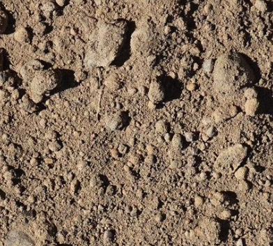 Close-up of dry, loose dirt or soil with small rocks and clumps.