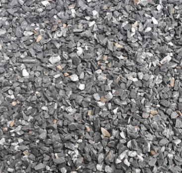 A ground surface covered with small gray and white rocks, with a coin and a small green object among the rocks.