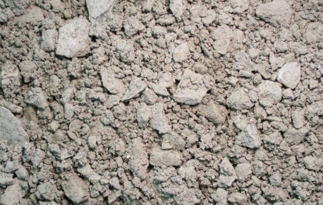 Close-up of dry, loose soil or dirt with small rocks and clumps.