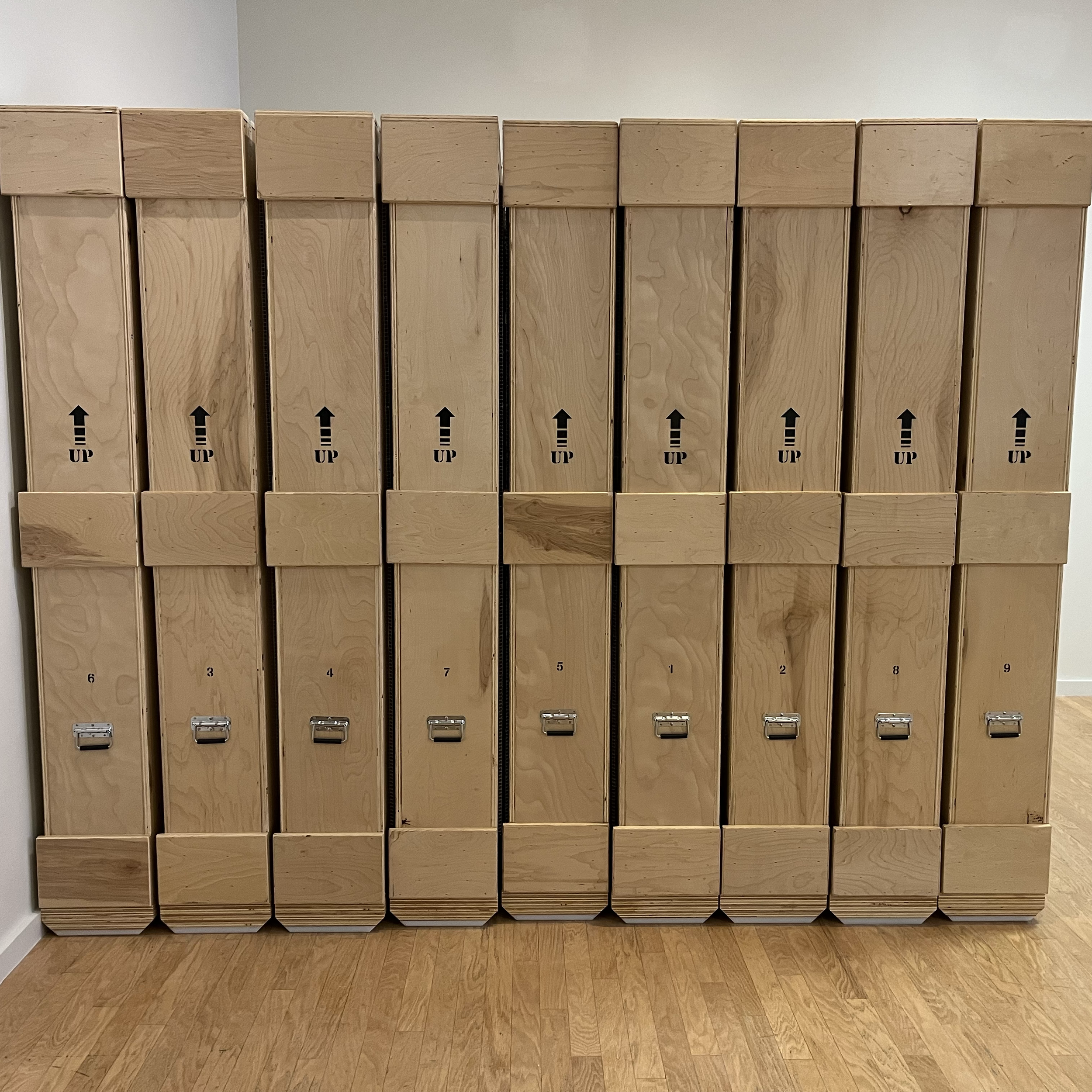 A row of wooden crates with metal handles.