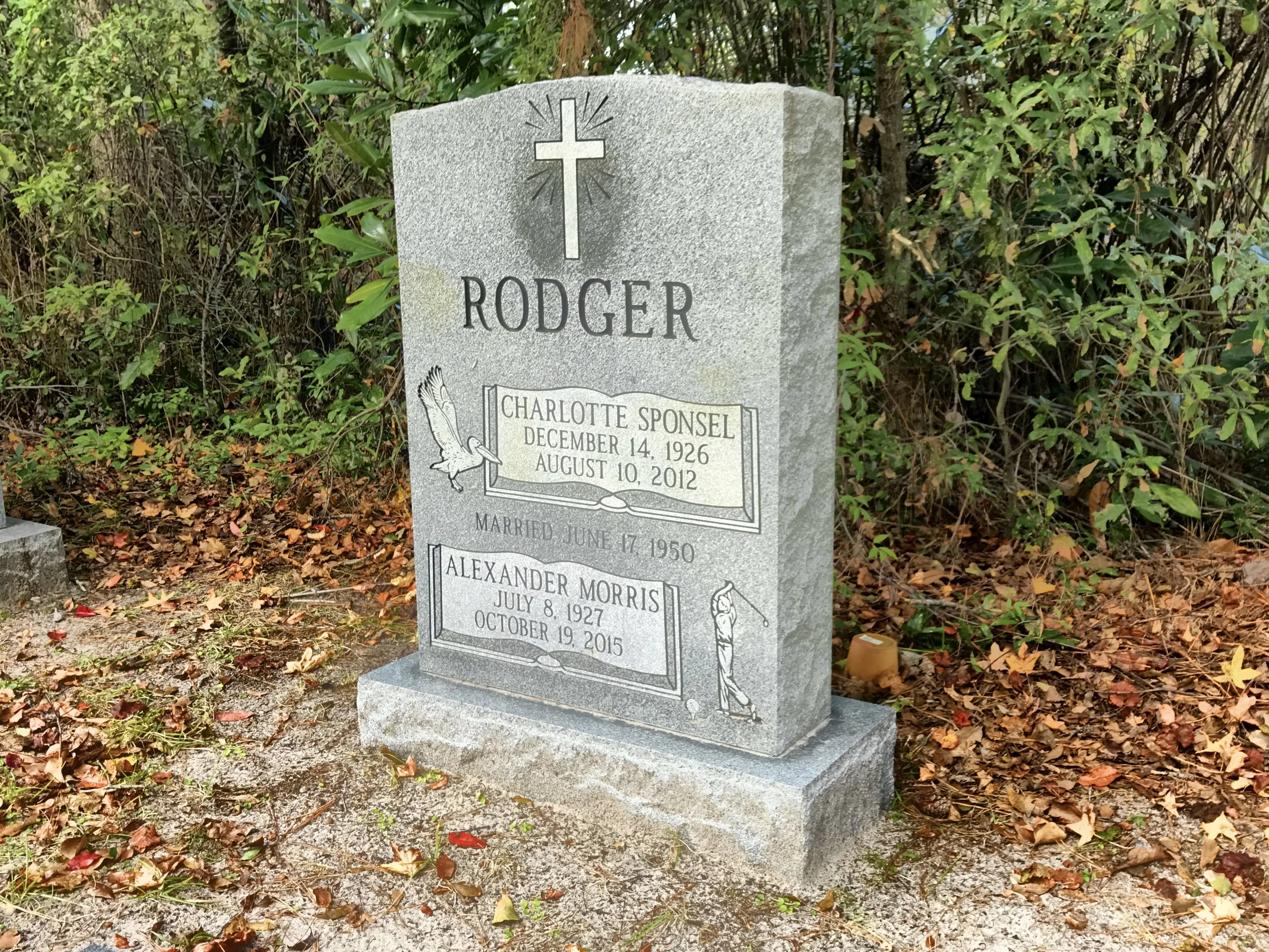 Gravestone in a cemetery with the name Rodgers and dates December 14, 1926, August 10, 2012, surrounded by fallen leaves and greenery.