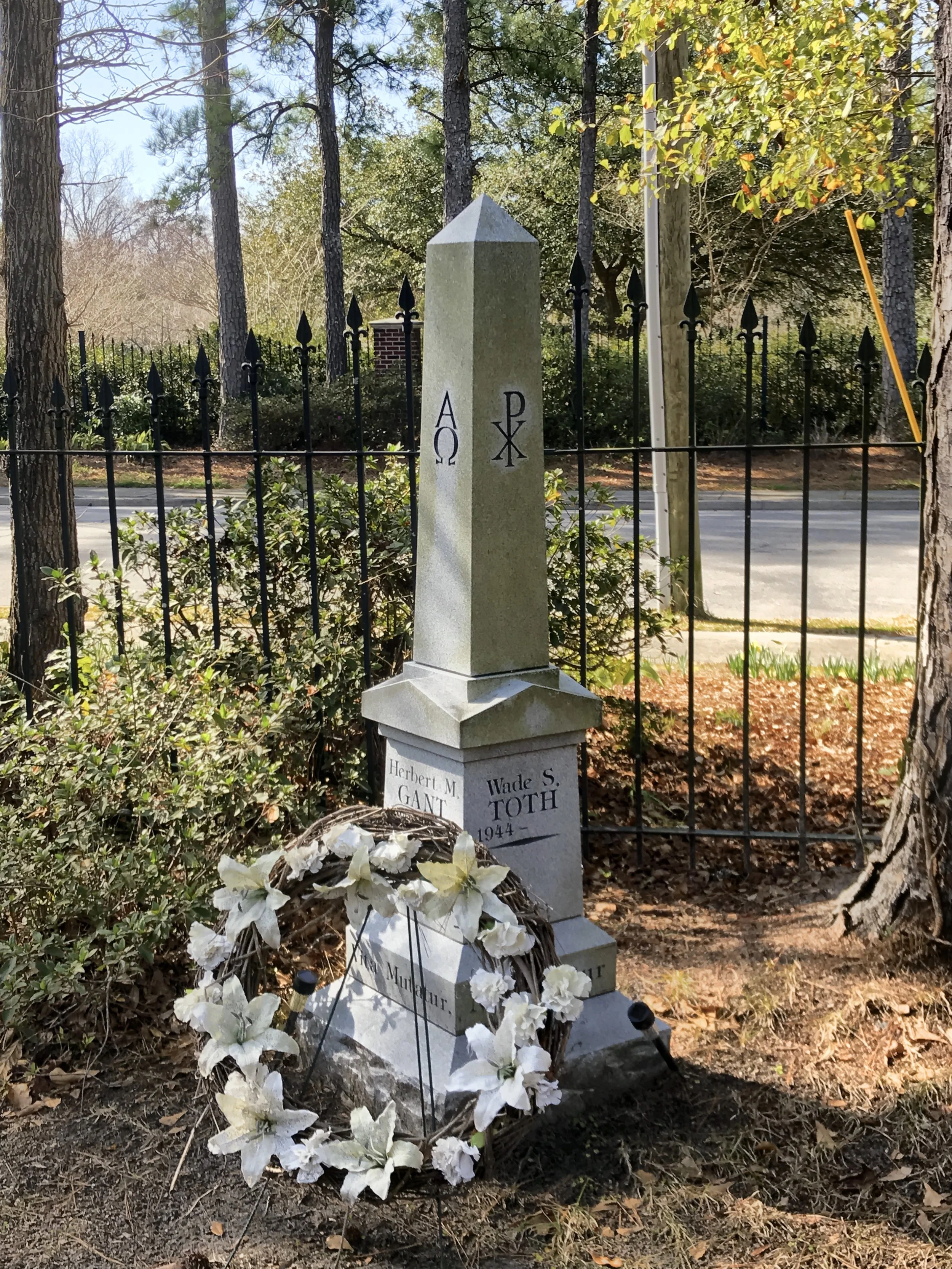 A personalized, obelisk granite memorial stone in a cemetery.