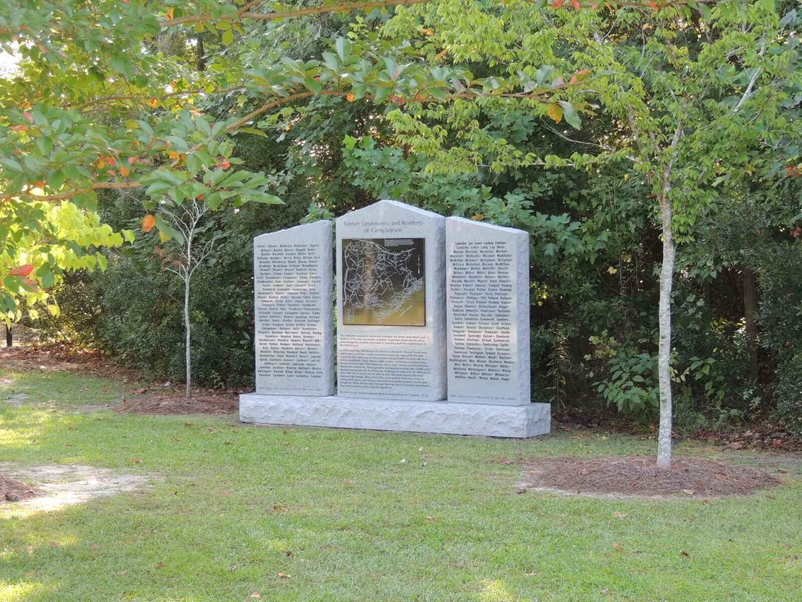 A large stone monument installation with engraved text and a detailed map of the area.