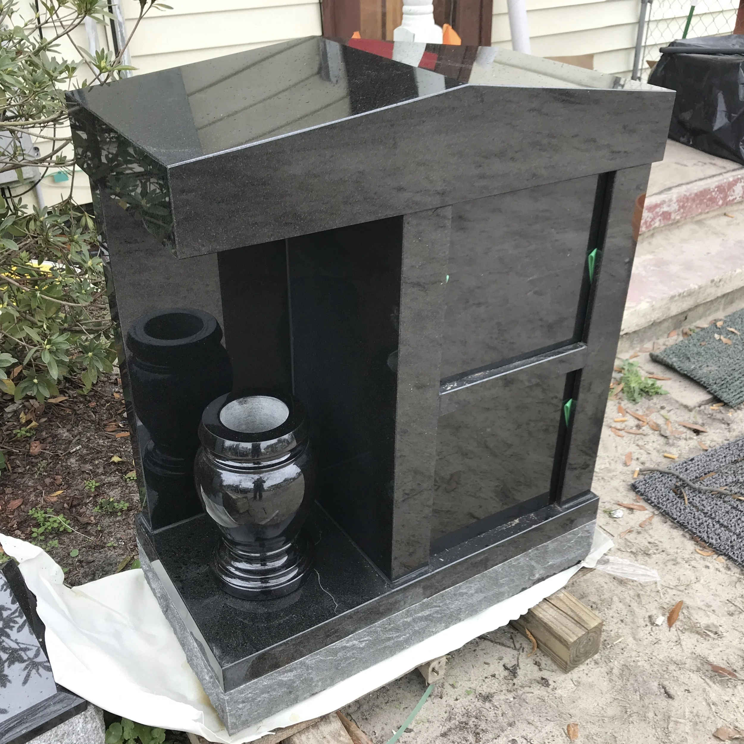 Polished black granite cremation memorial with an engraved inscription.