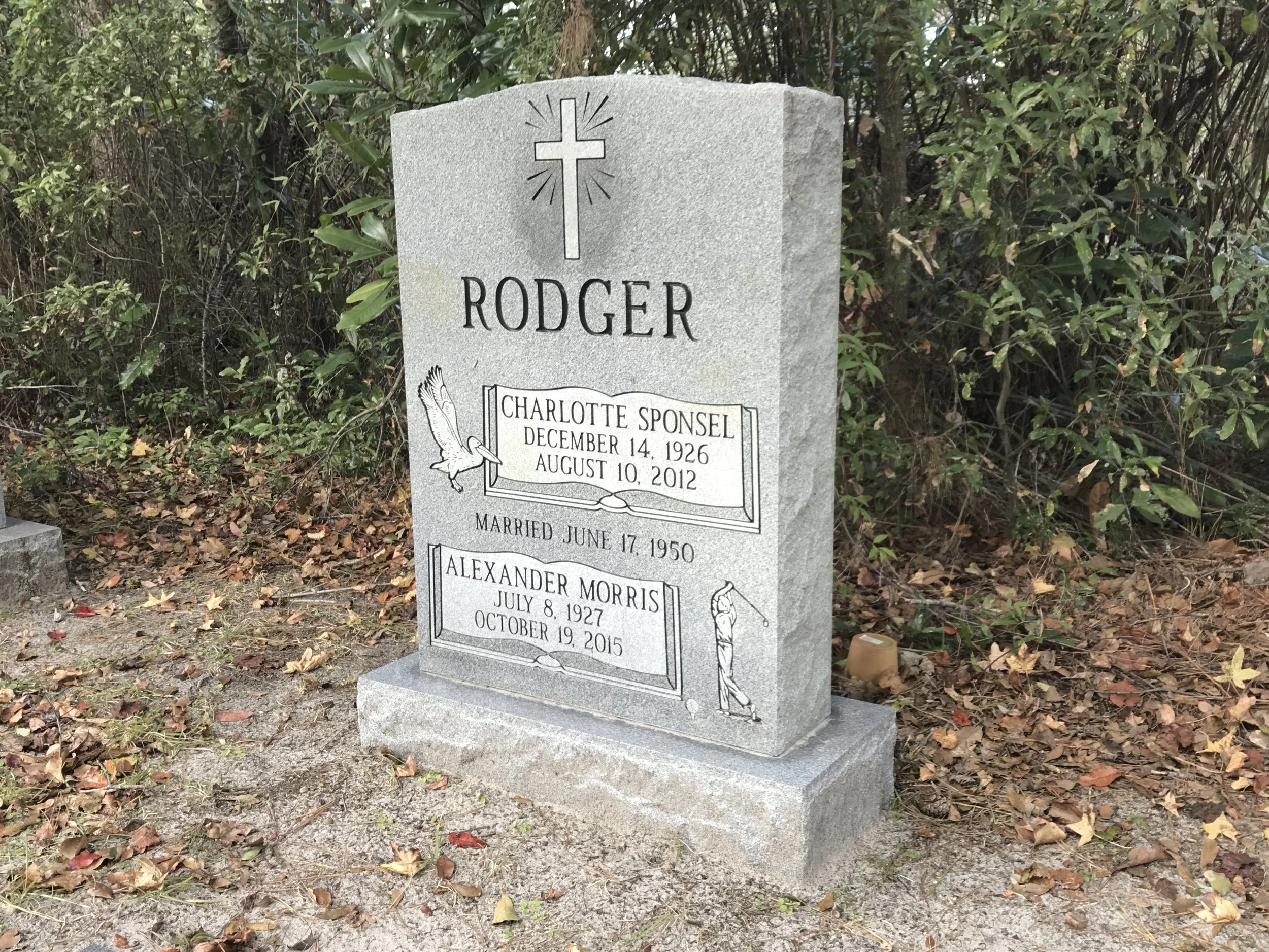 Gray granite gravestone with a cross and the name Rodgers. It lists three names with birth and death dates: Charlotte Sponzel (December 14, 1926 - August 10, 2012), Alexander Morris (July 8, 1927 - October 19, 2015), and an incomplete name.