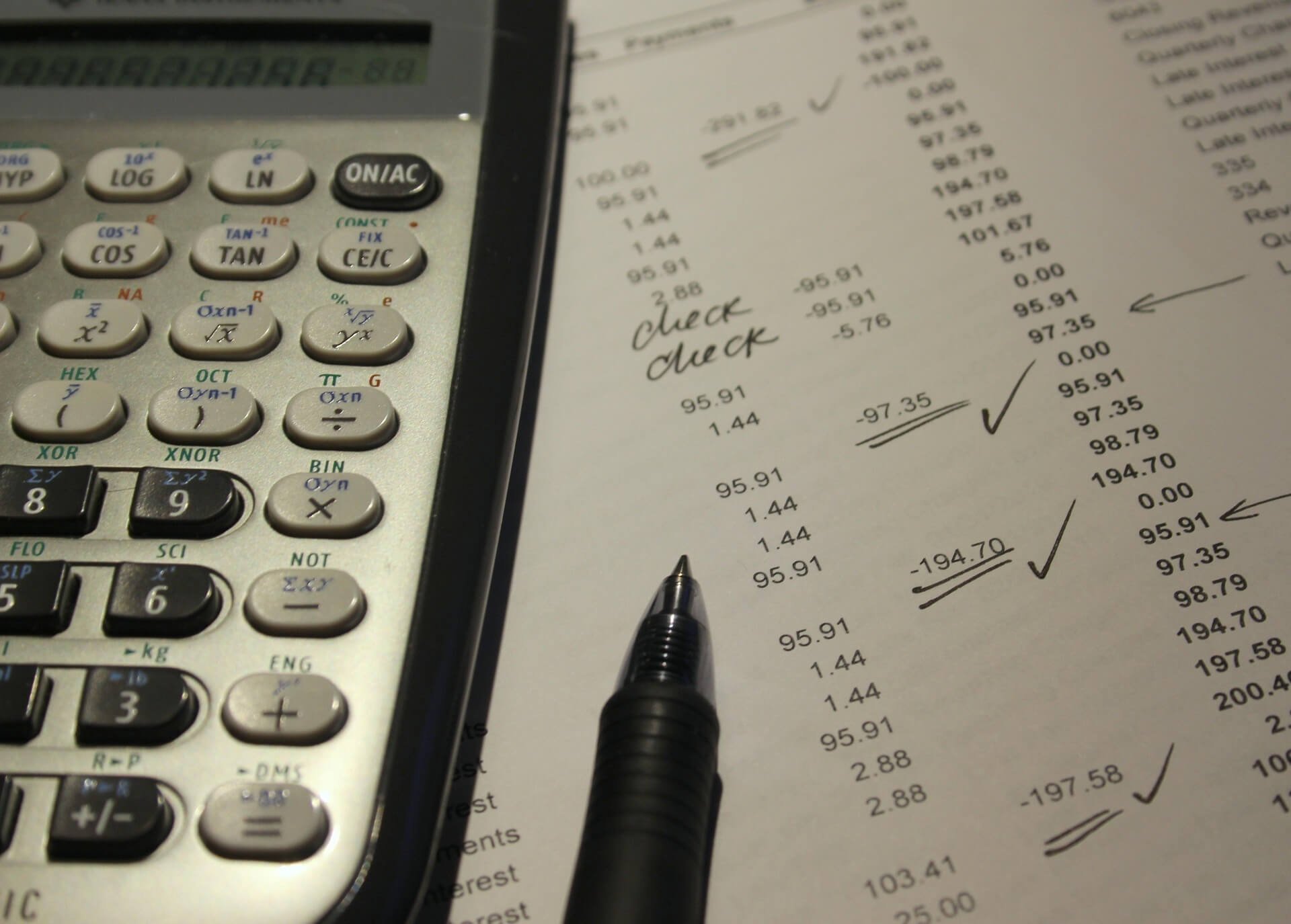 Photo of calculator and a pen resting on a printed receipt  | Northstar Trust Accounting | HOA Financials | Monthly Reconciliation | AppFolio | DRE Compliance | Property Management Accounting
