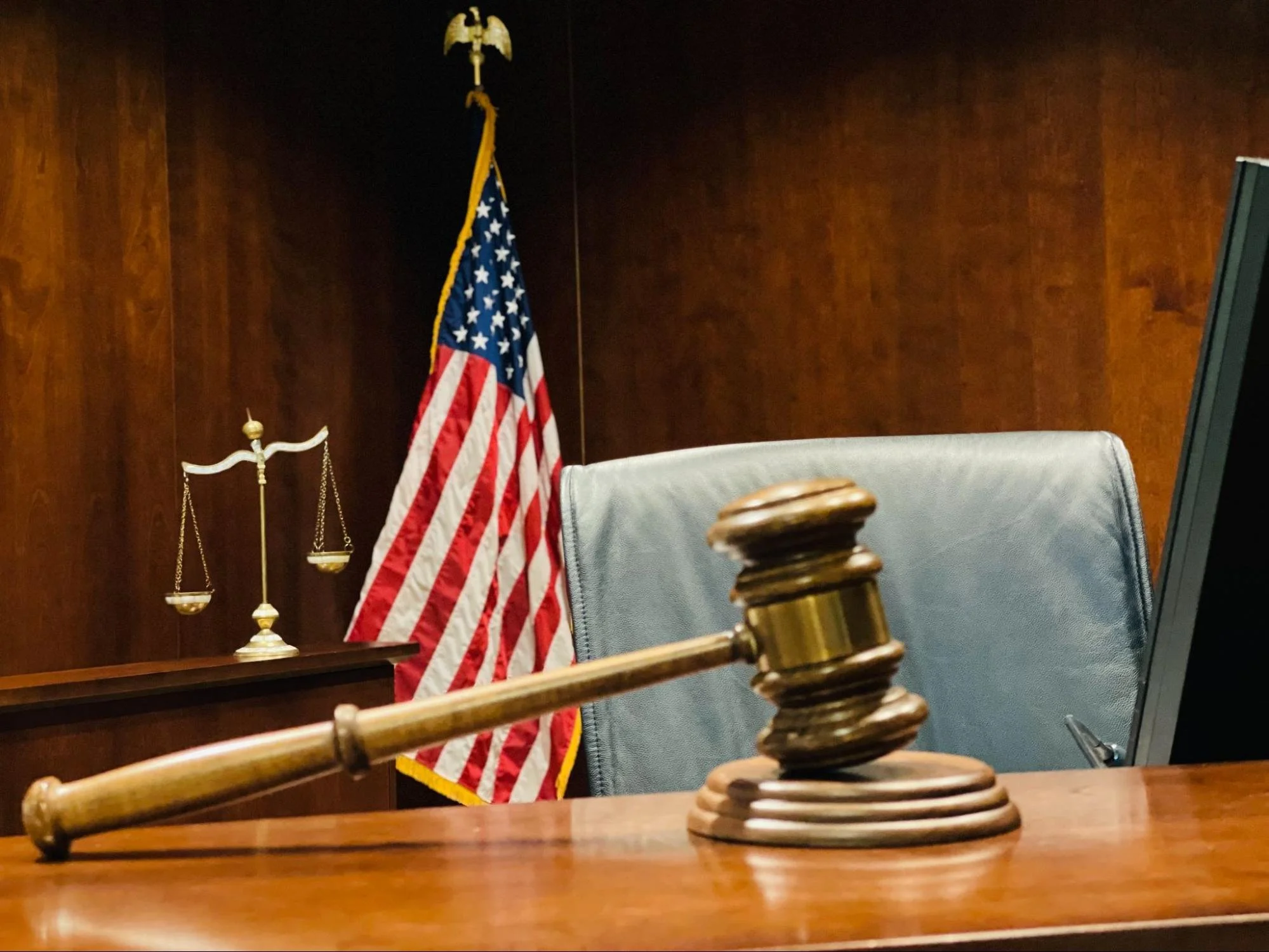 Gavel next to an American flag and a scale.