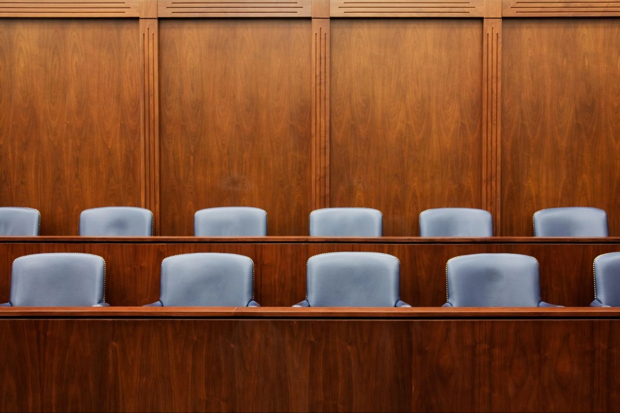 Empty seats in a courtroom.