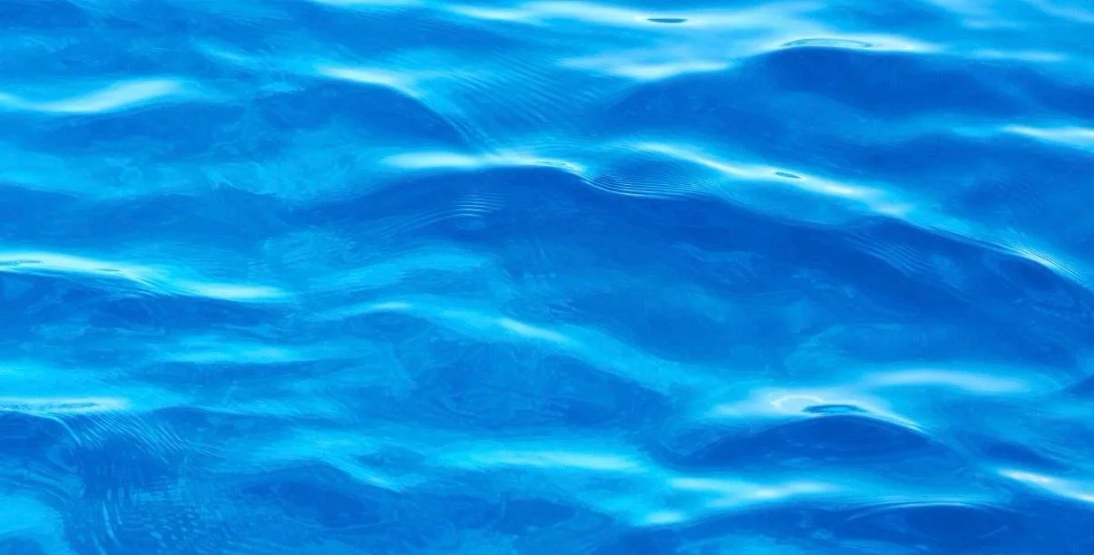 Close-up of blue ocean water with gentle waves and reflections.