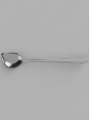 A stainless steel spoon placed horizontally on a plain gray background.