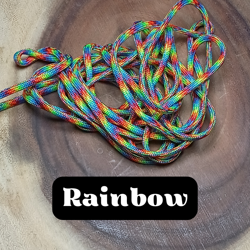 Colorful rainbow-striped shoelaces tangled on a wooden surface with the word "Rainbow" written below.